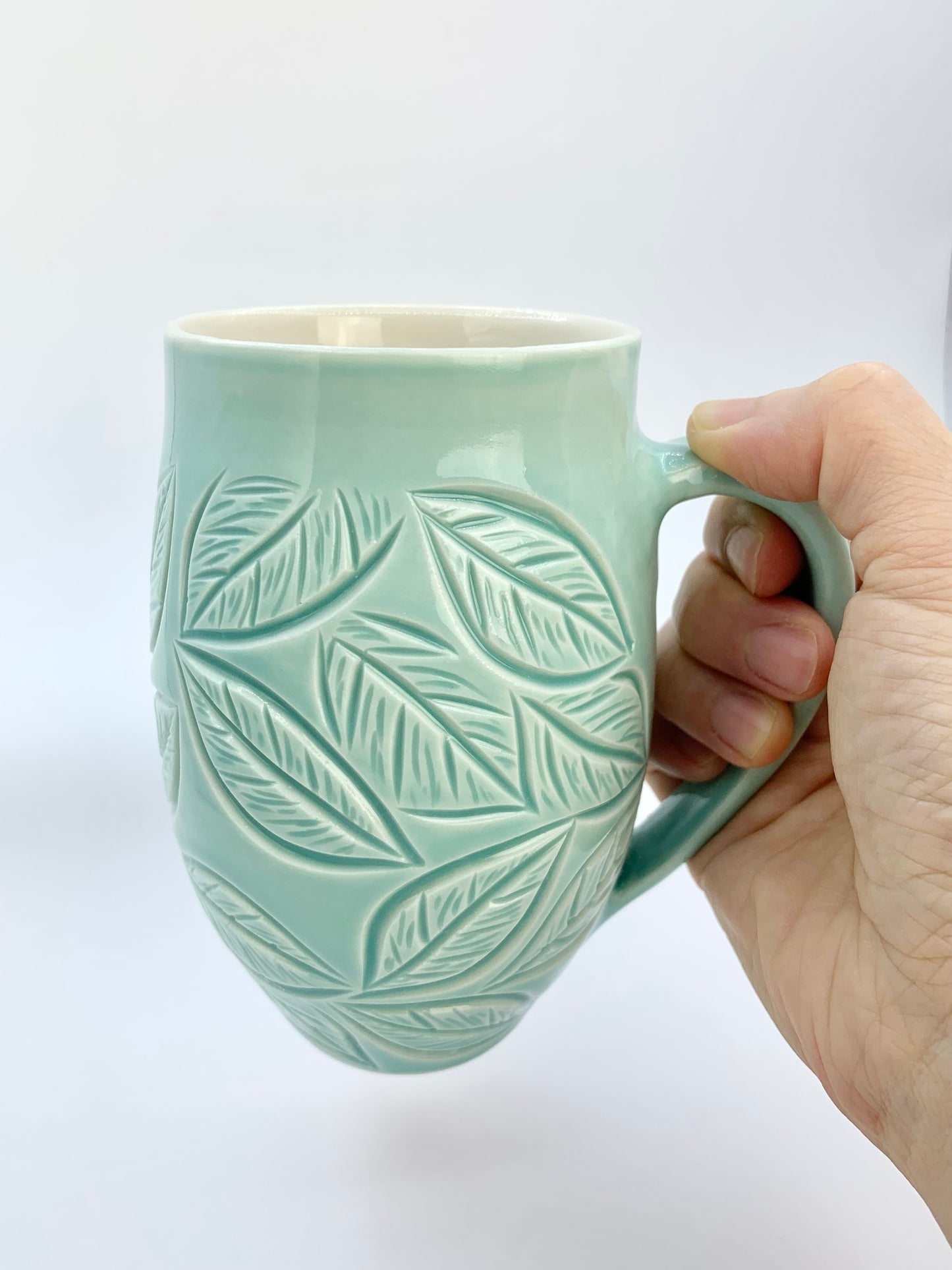 Large porcelain mug with leaf carvings in turquoise