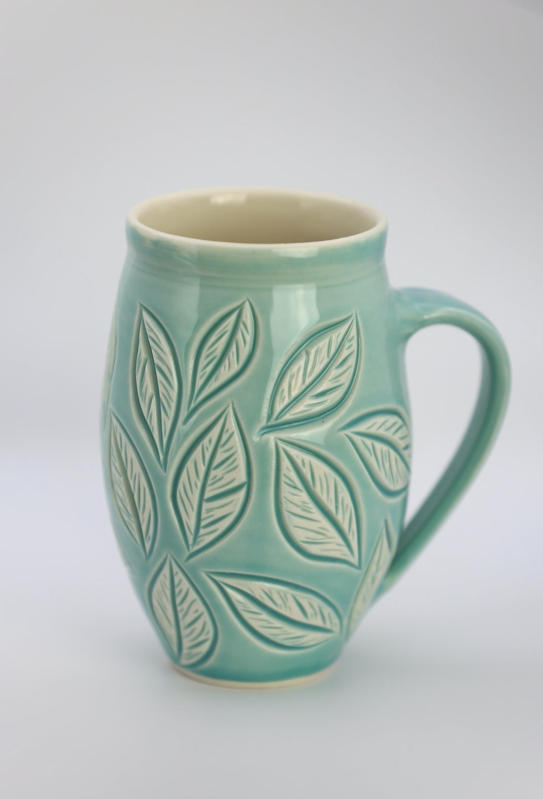 Large porcelain mug with leaf carvings in turquoise