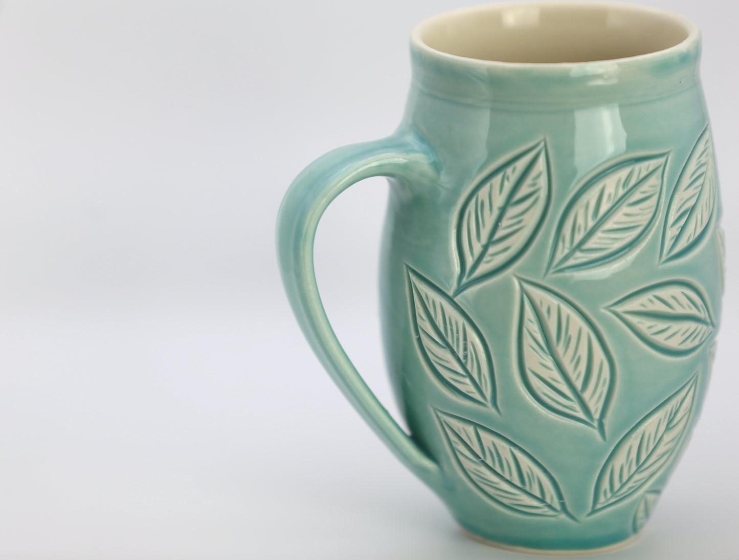 Large porcelain mug with leaf carvings in turquoise