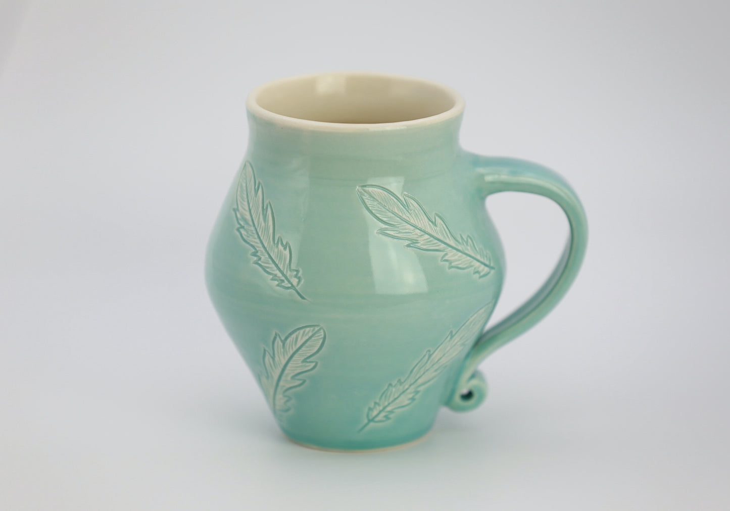 12 oz porcelain mug with feather carvings in turquoise