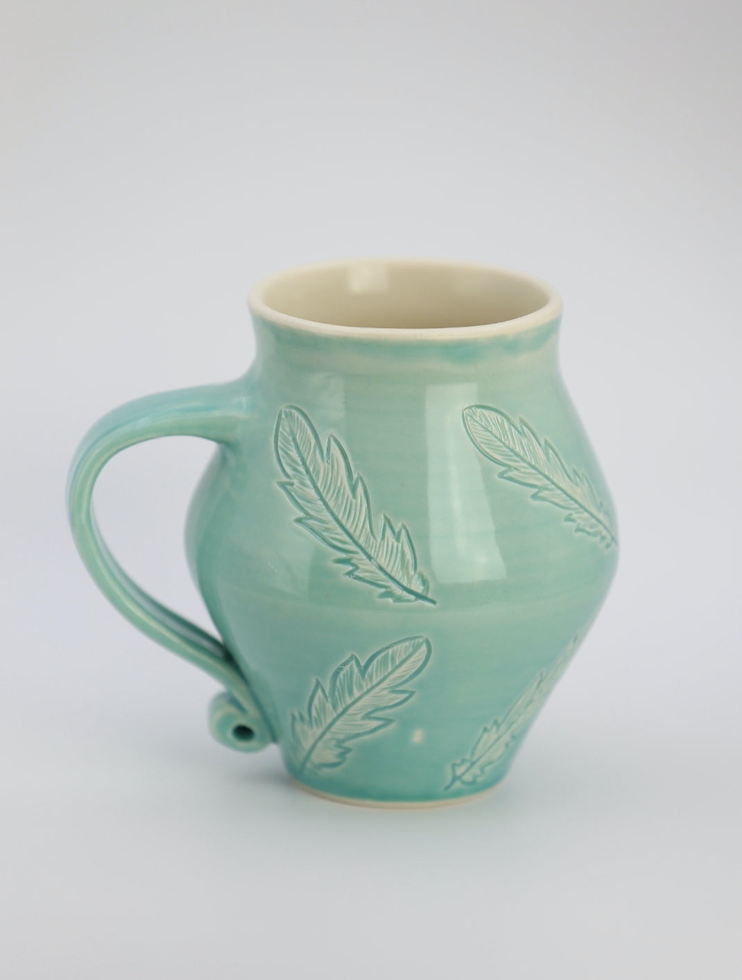 12 oz porcelain mug with feather carvings in turquoise