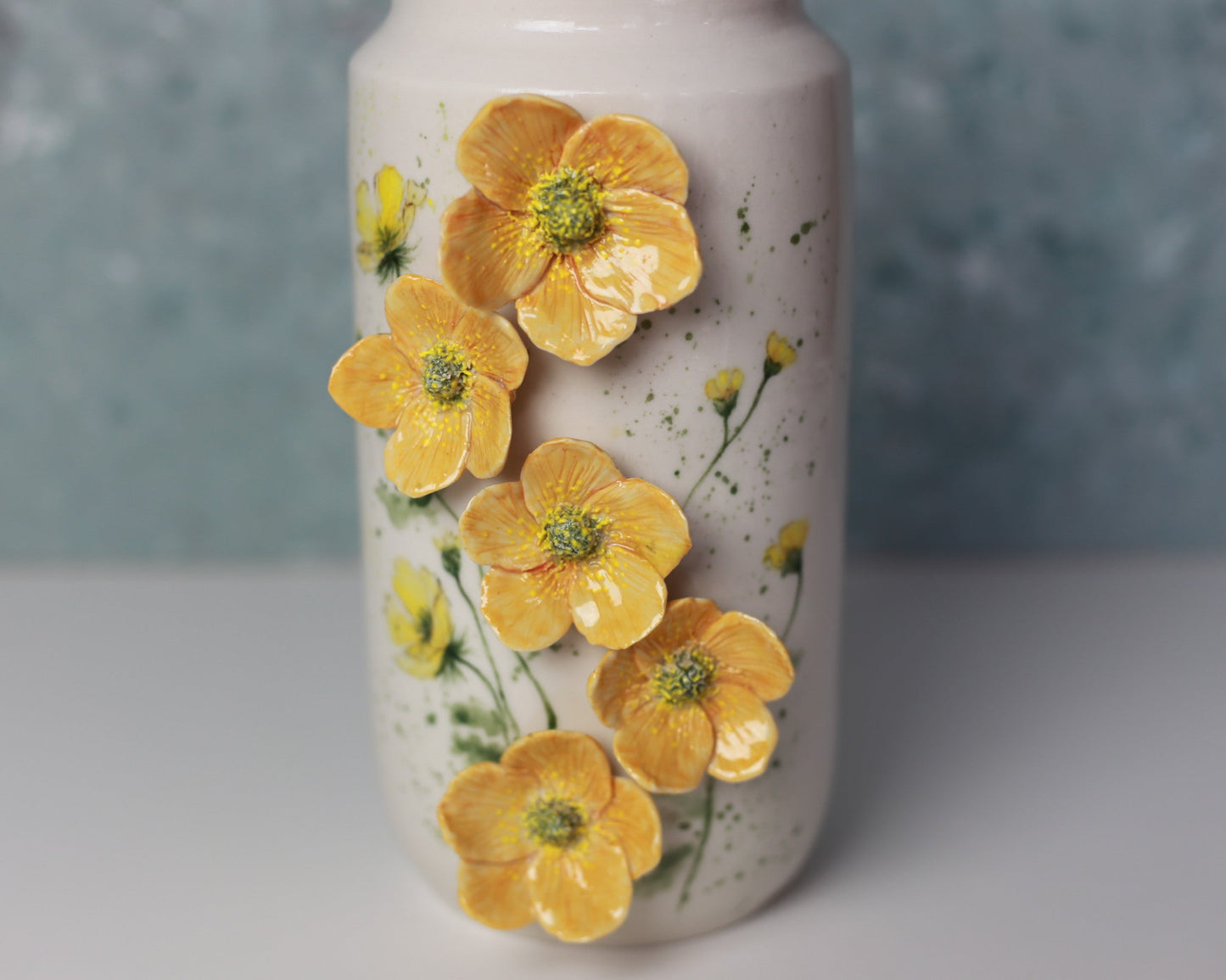 Ceramic vase with yellow floral design on a textured surface