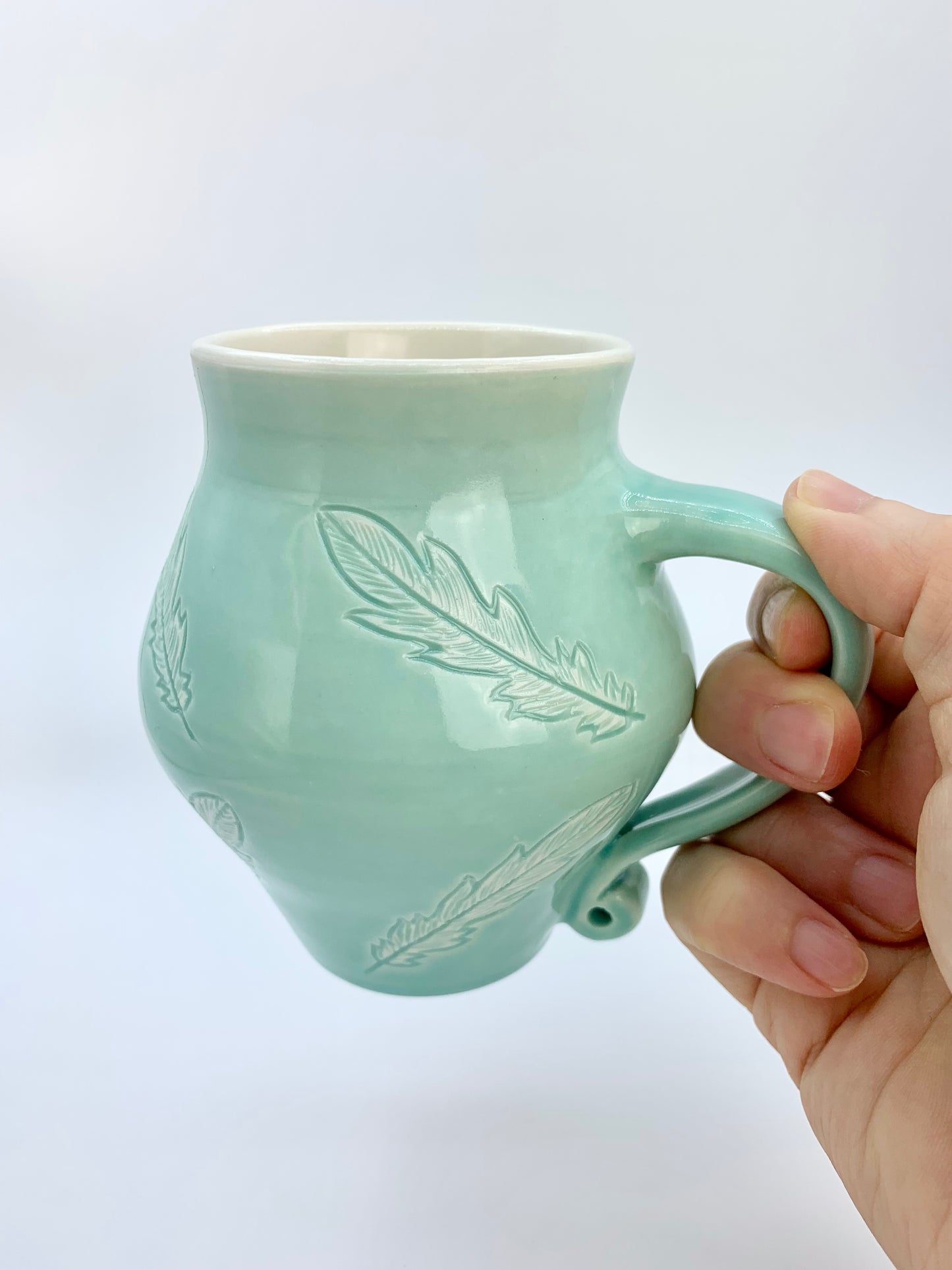 12 oz porcelain mug with feather carvings in turquoise