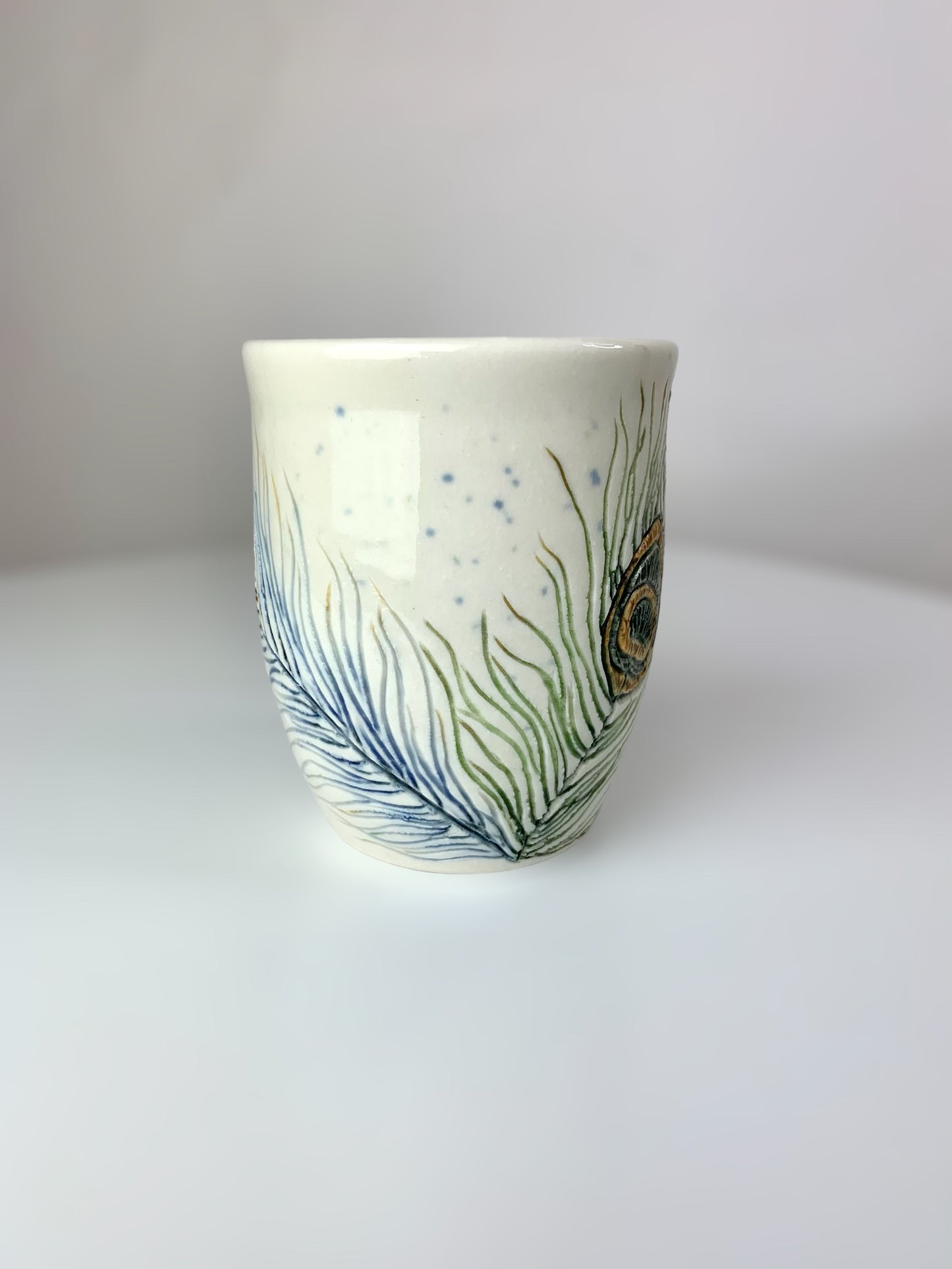 Porcelain mug with peacock feathers