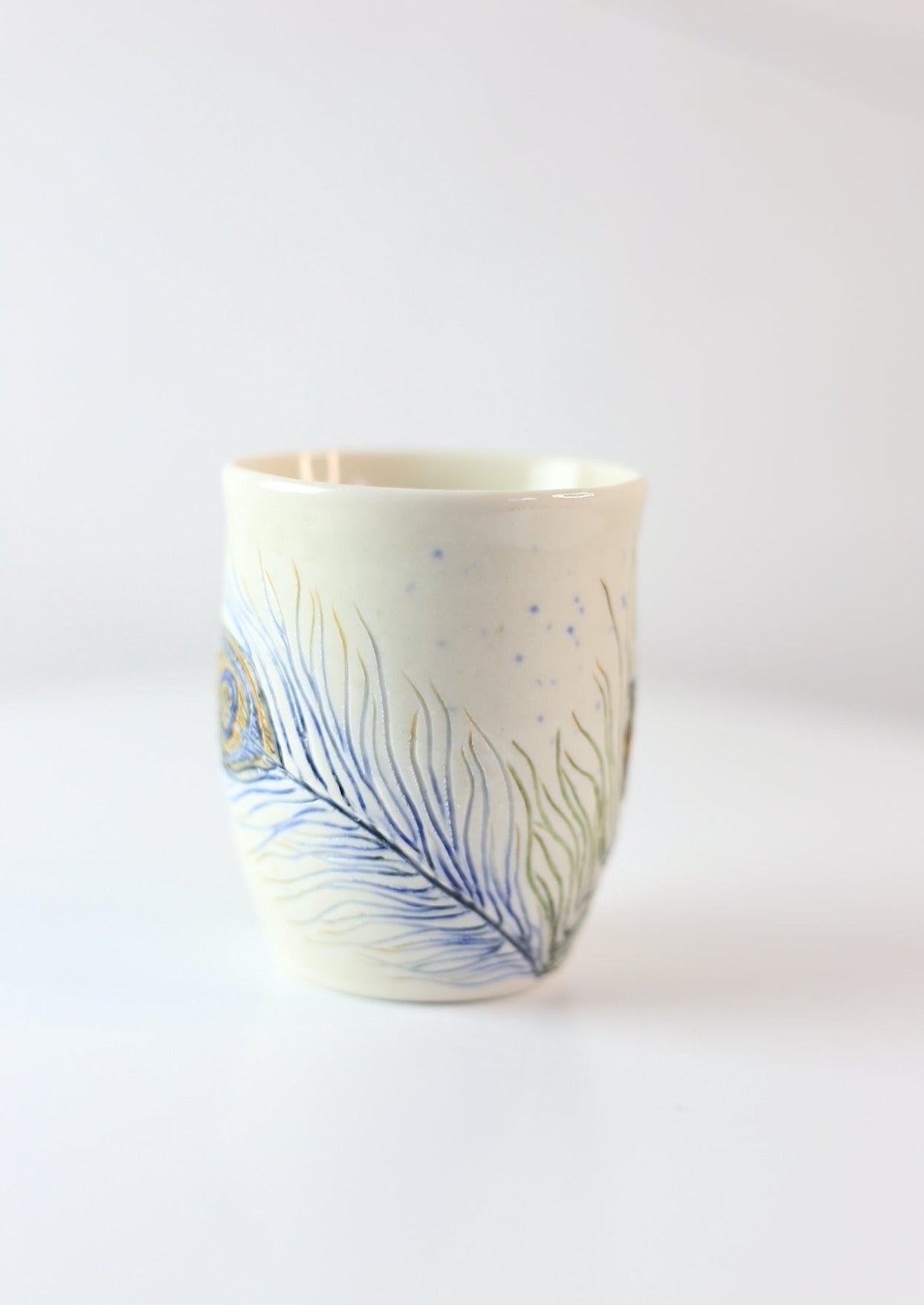 Porcelain mug with peacock feathers