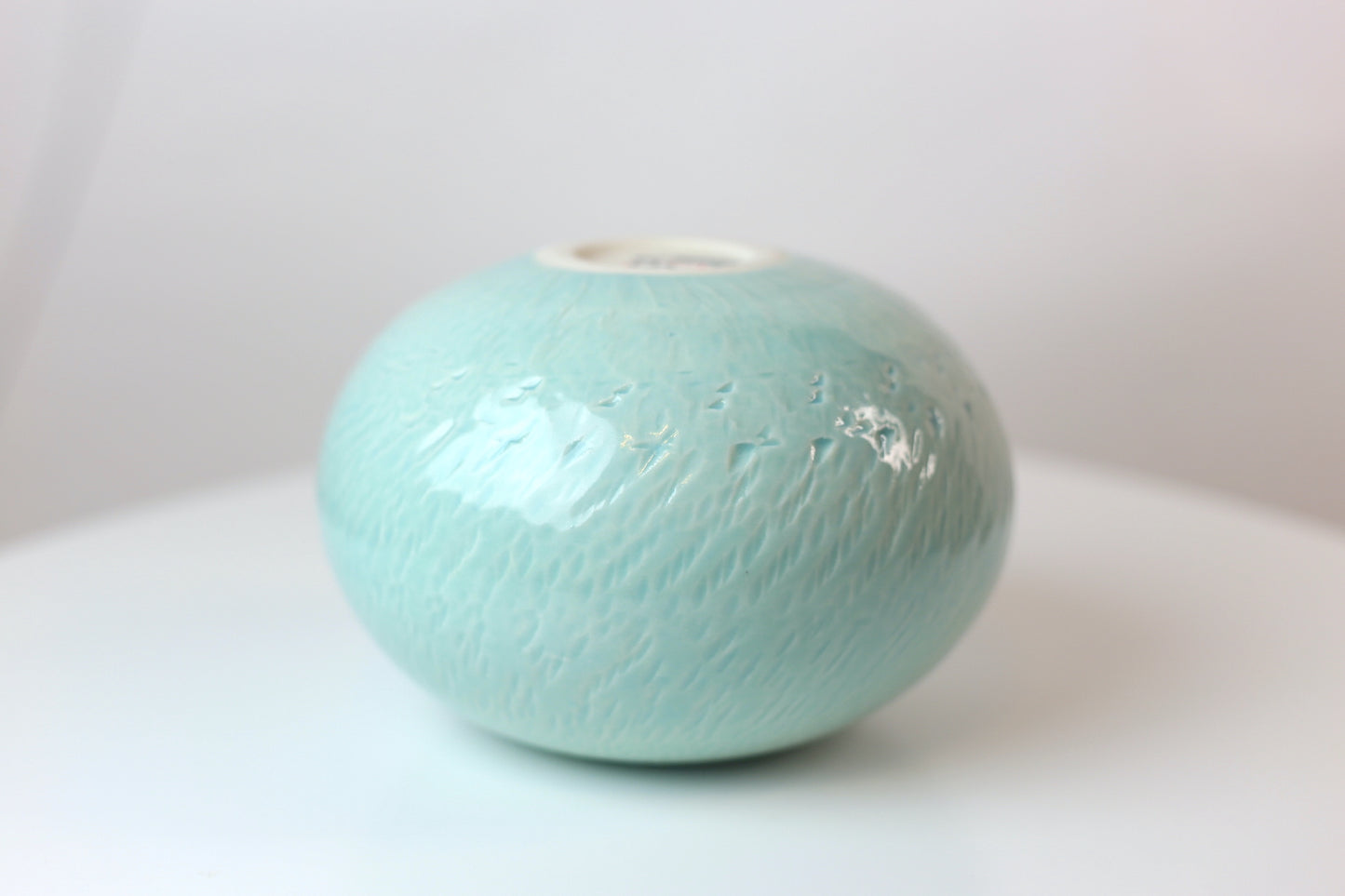 Bulbous round porcelain vase with texture in turquoise