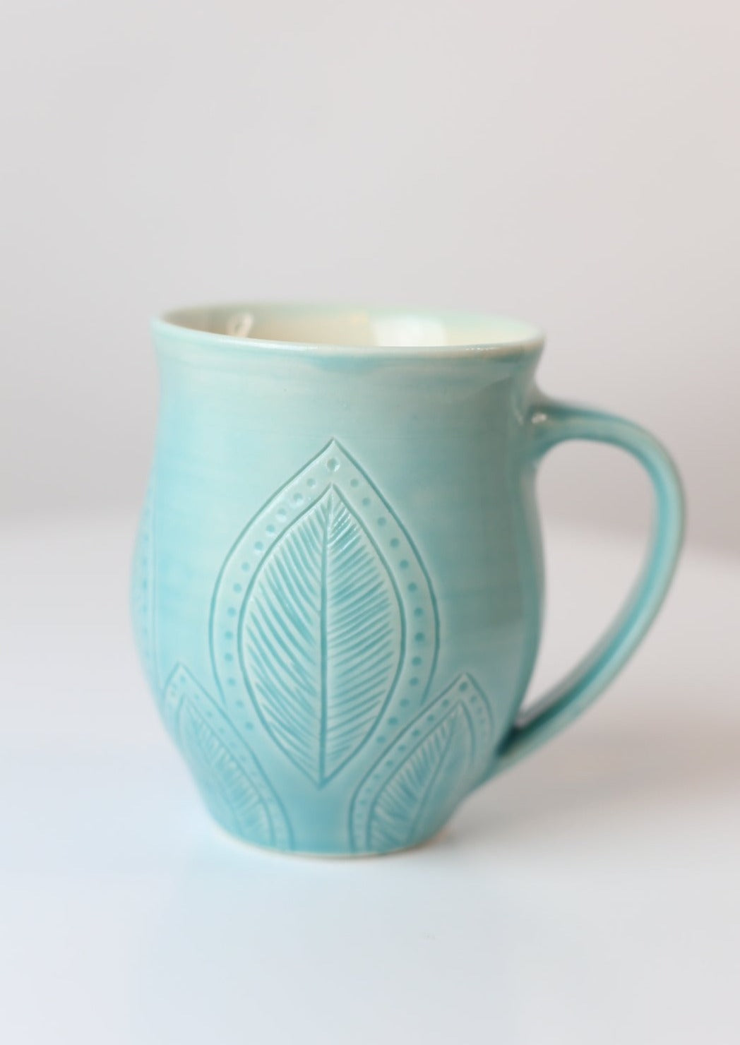 12oz porcelain mug with feather leaf design in turquoise
