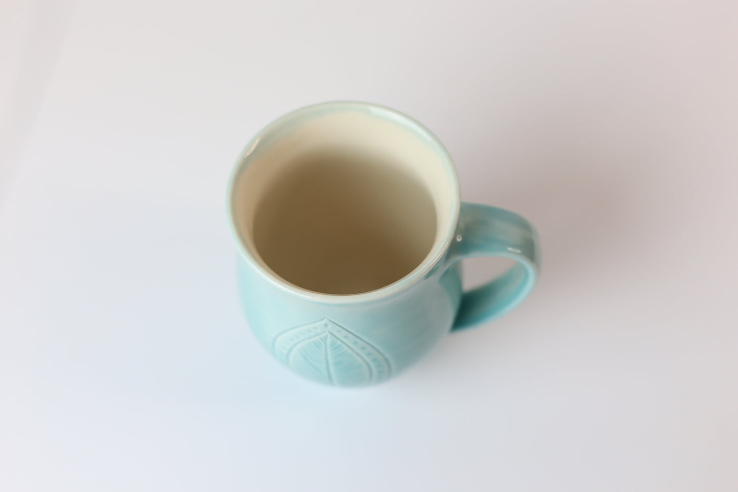 12oz porcelain mug with feather leaf design in turquoise