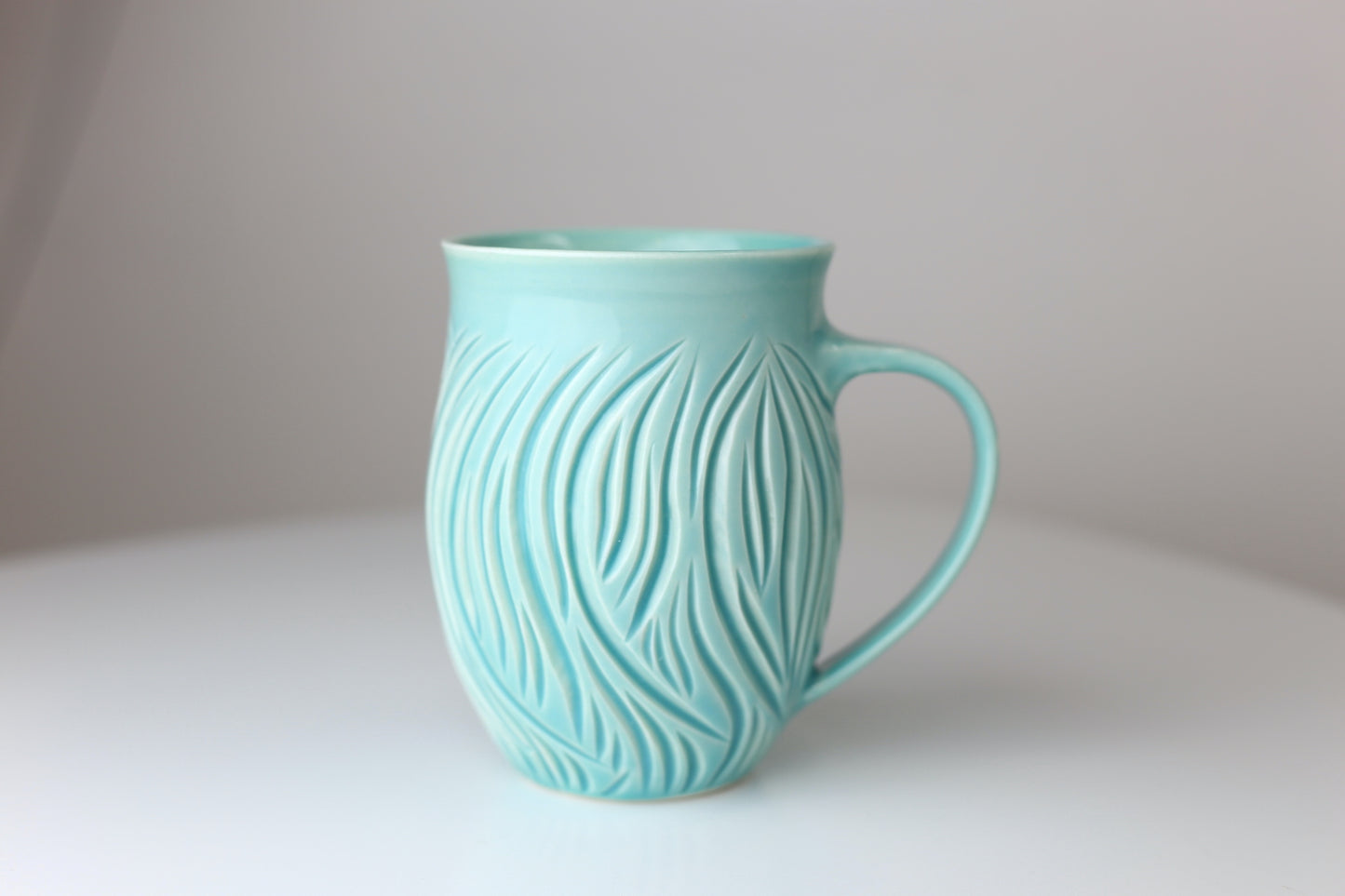 Large porcelain mug with abstract carvings in turquoise