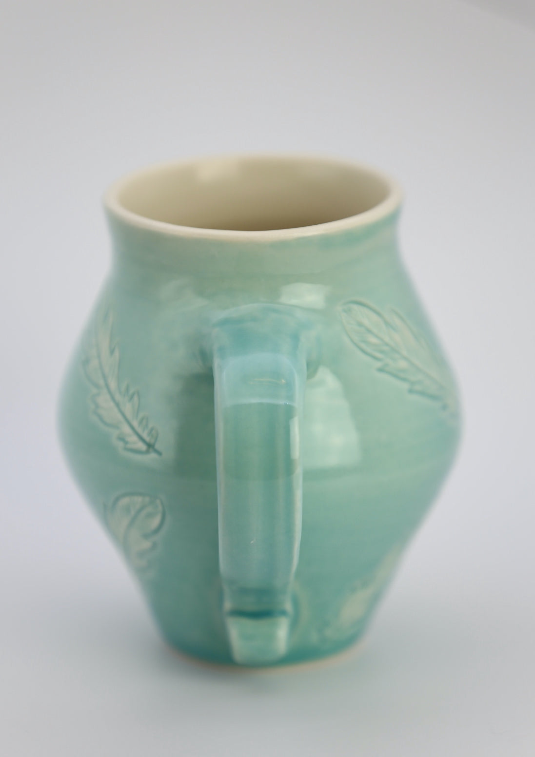 12 oz porcelain mug with feather carvings in turquoise