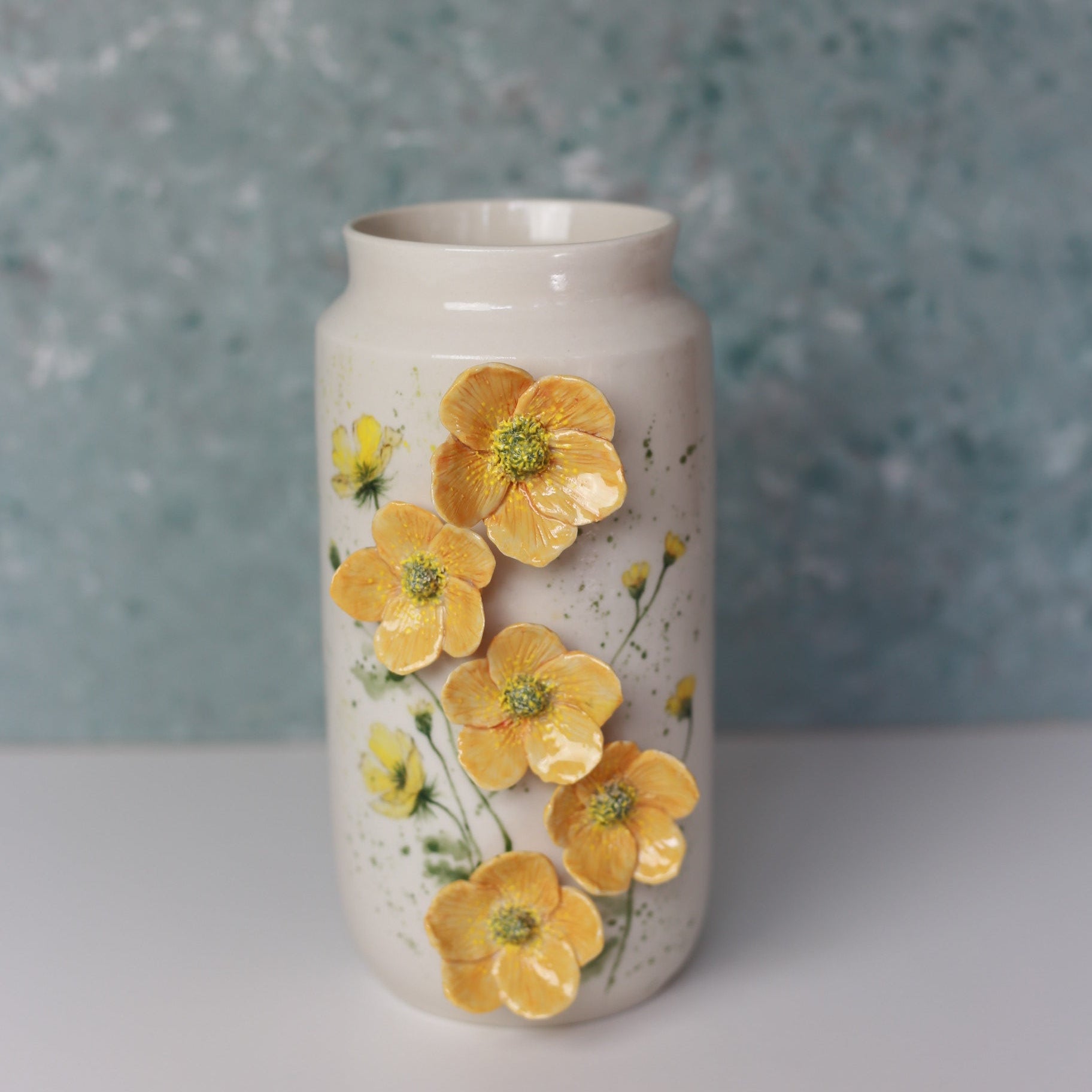 Decorative vase with yellow floral design on a textured surface
