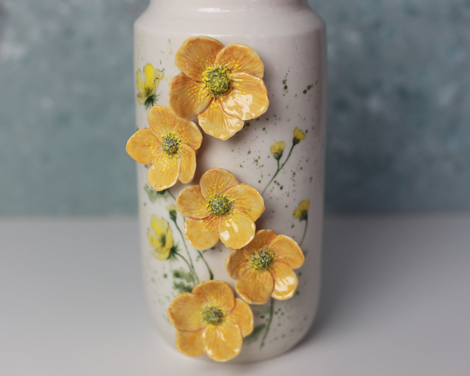 Ceramic vase with yellow floral design on a textured surface