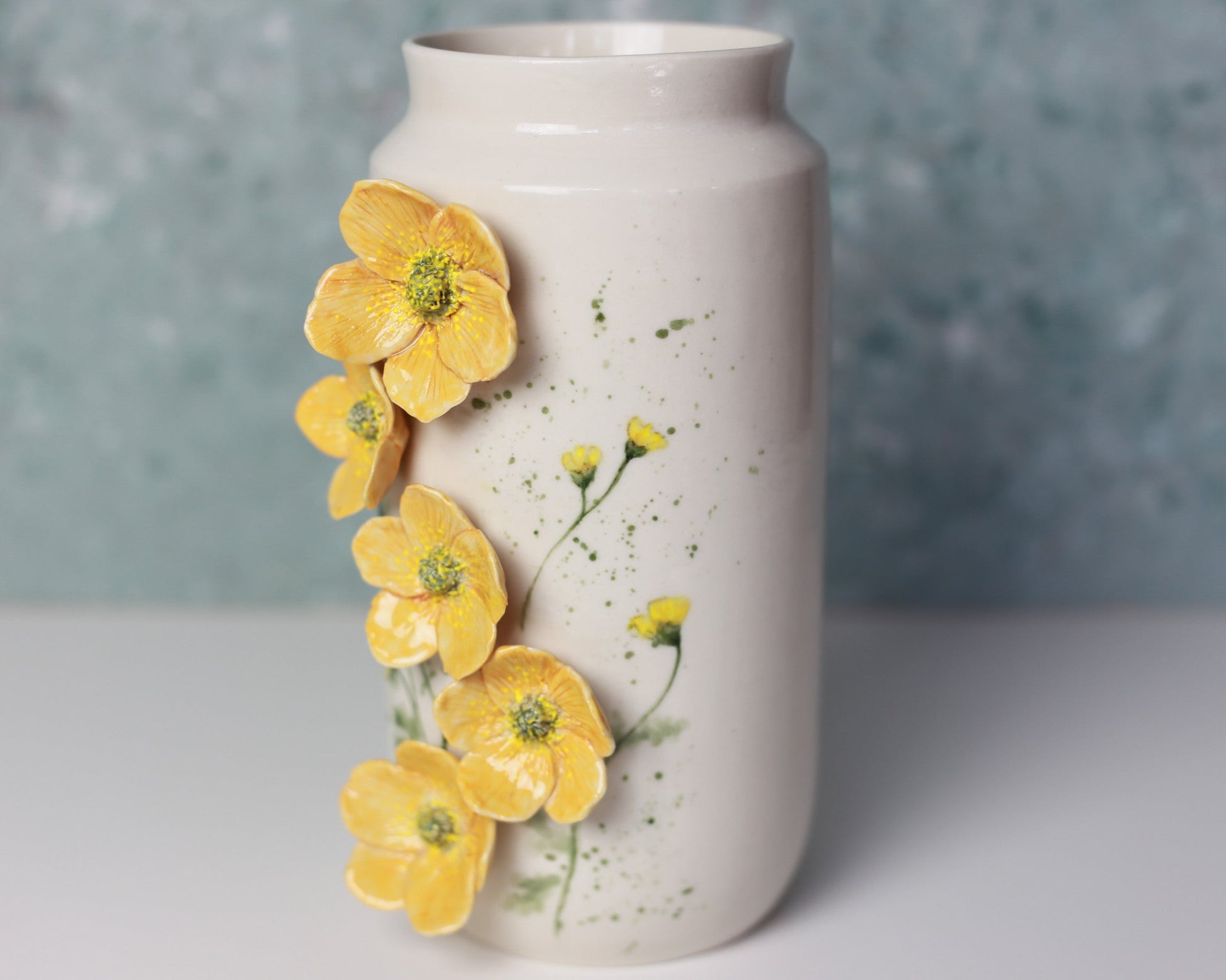 White vase with yellow floral decorations on a gray background
