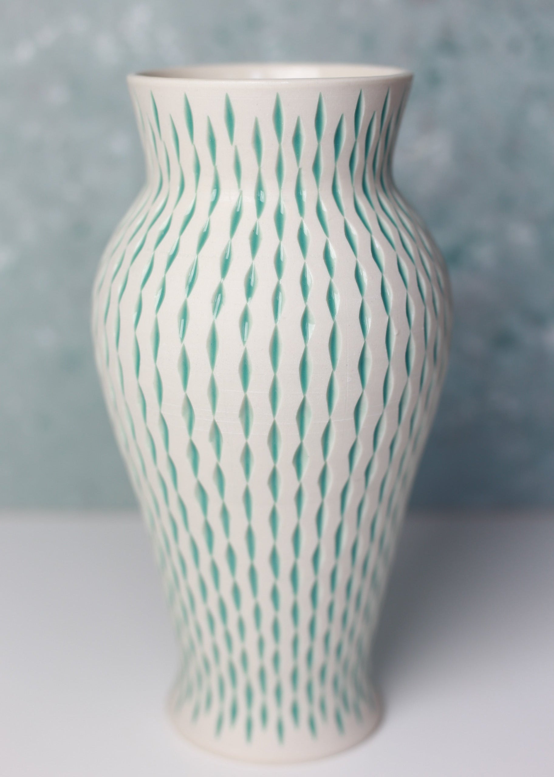 Vase with wavy green lines on a blurred background
