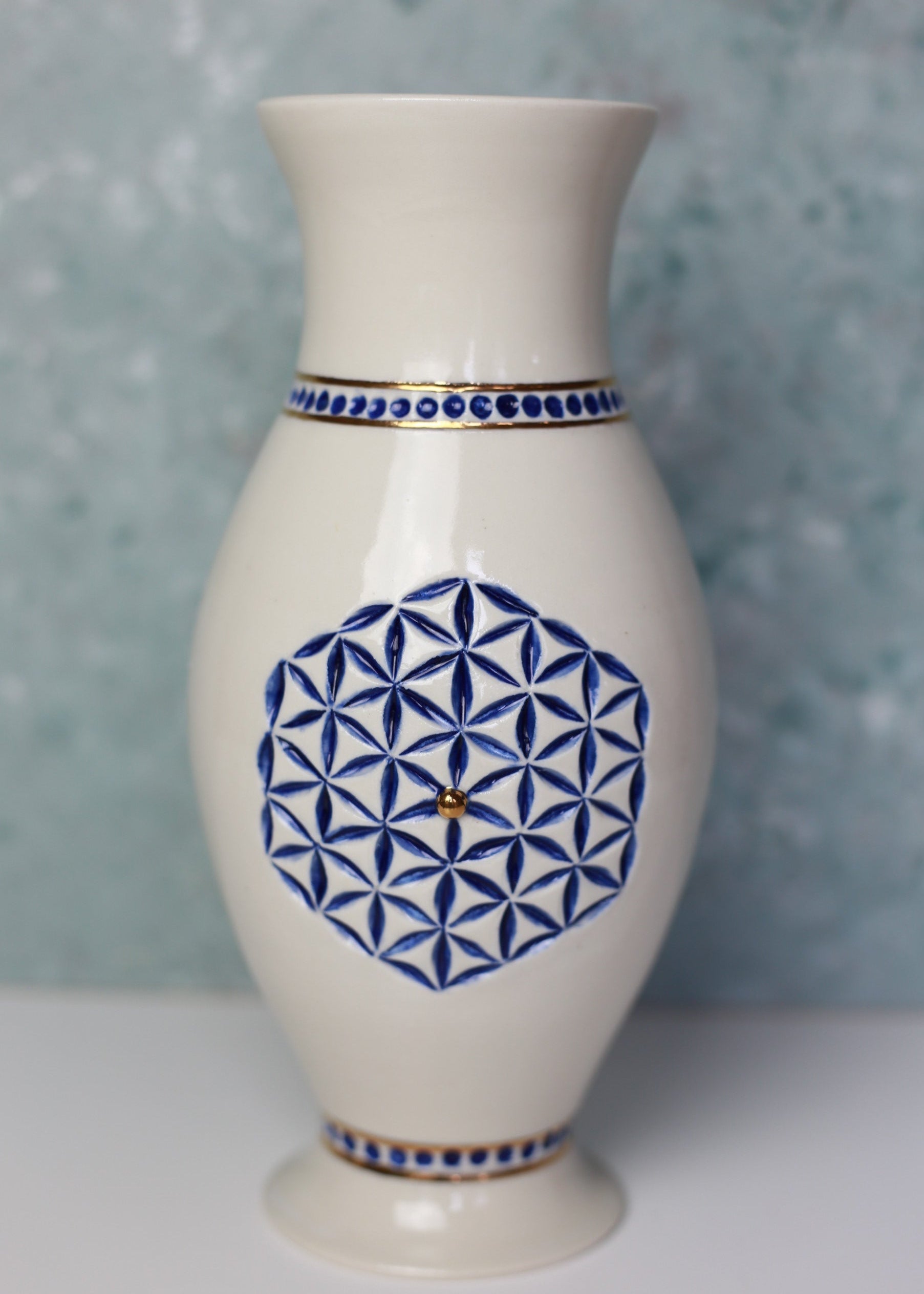 White vase with blue geometric pattern on a light gray background