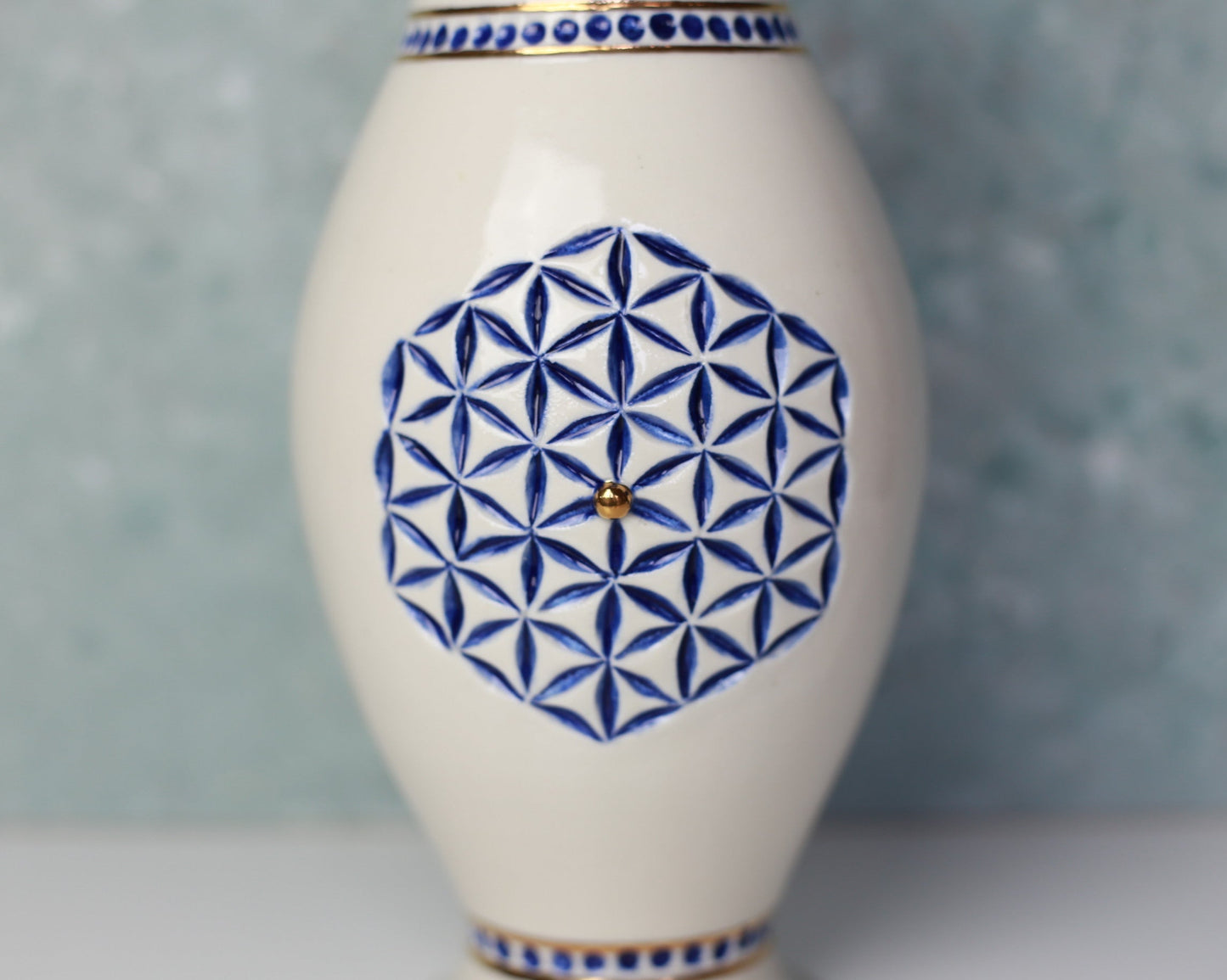 White vase with blue geometric pattern on a gray background