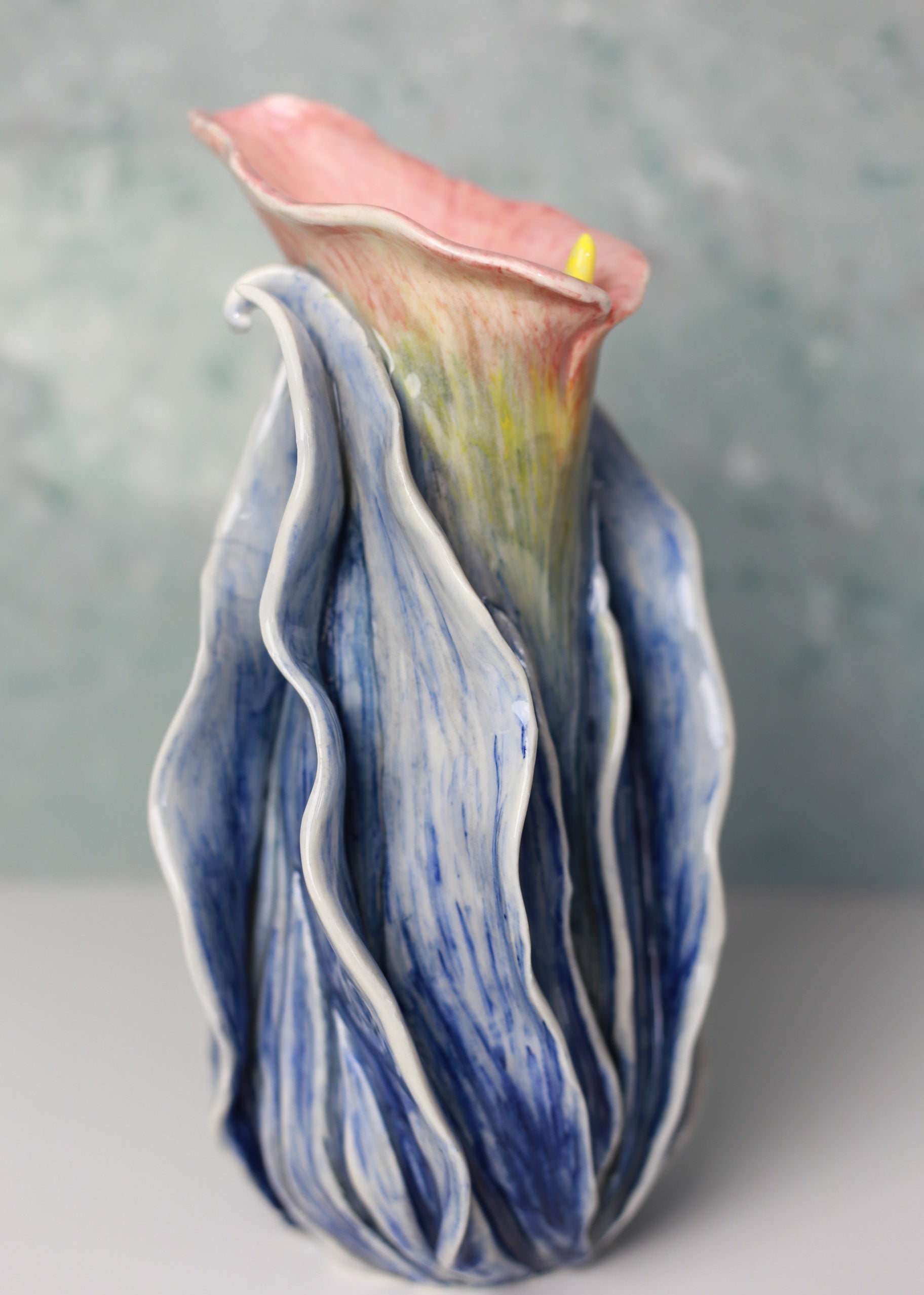 Ceramic vase with blue and pink design on a gray background