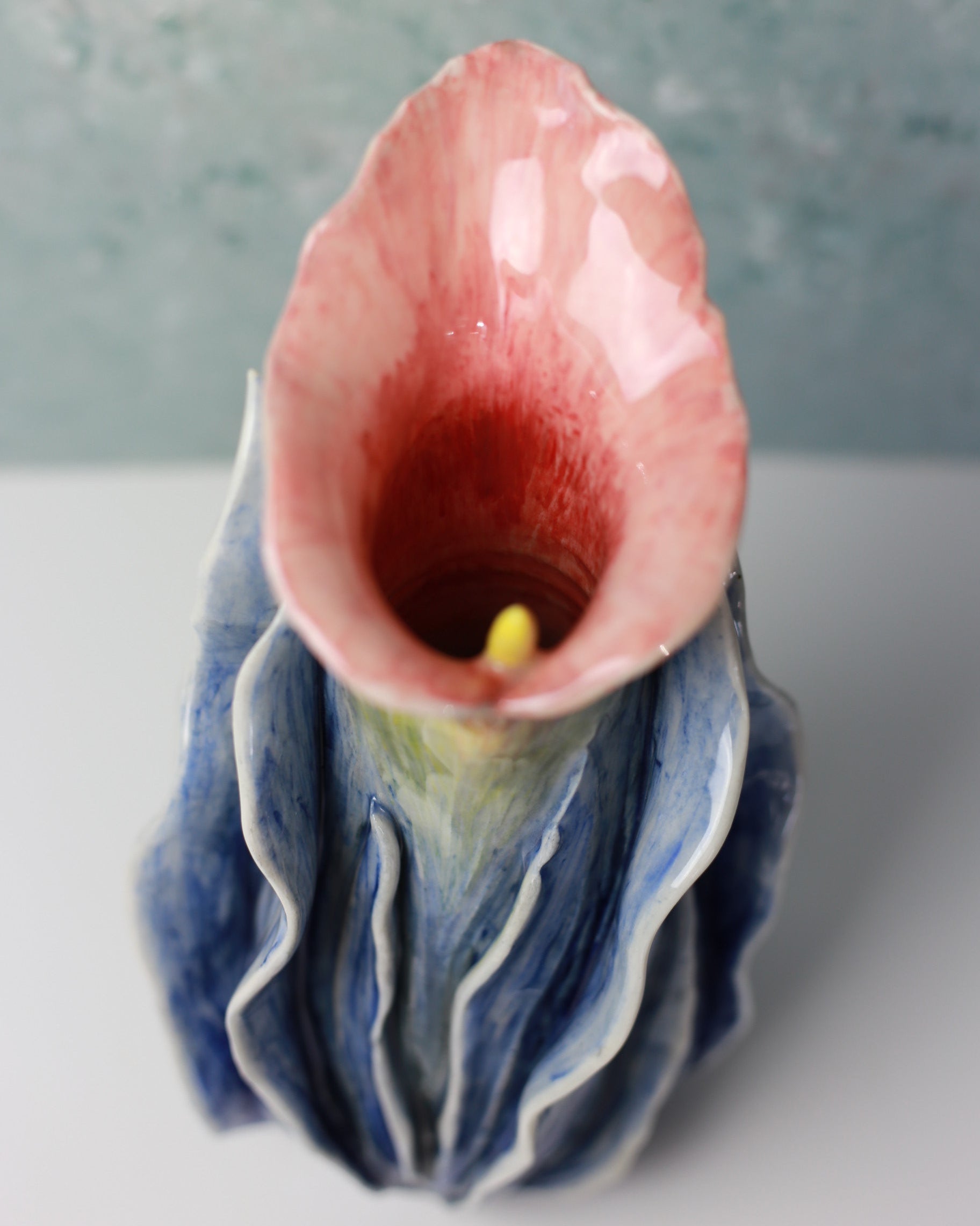 Close-up of a decorative ceramic vase with a floral design on a light background