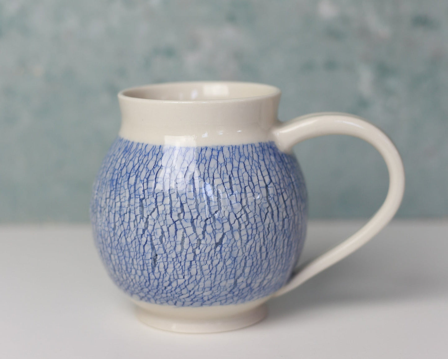 Blue textured mug with a white base against a light background