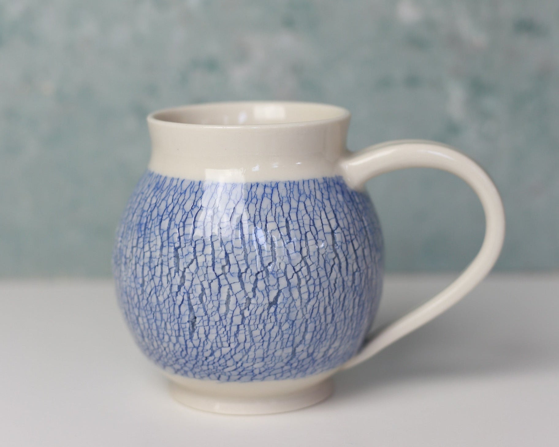 Blue textured mug with a white base against a light background