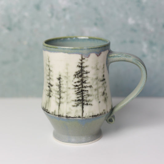 Ceramic mug with tree design on a gray background