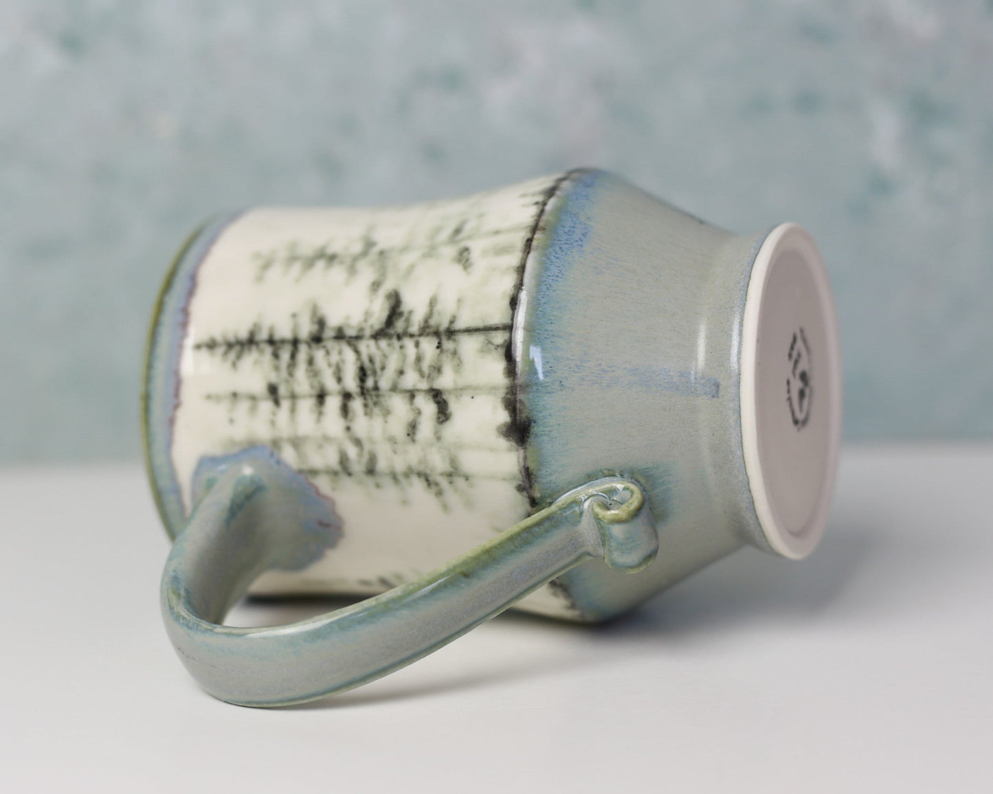 Ceramic mug with textured design on a white surface and gray background