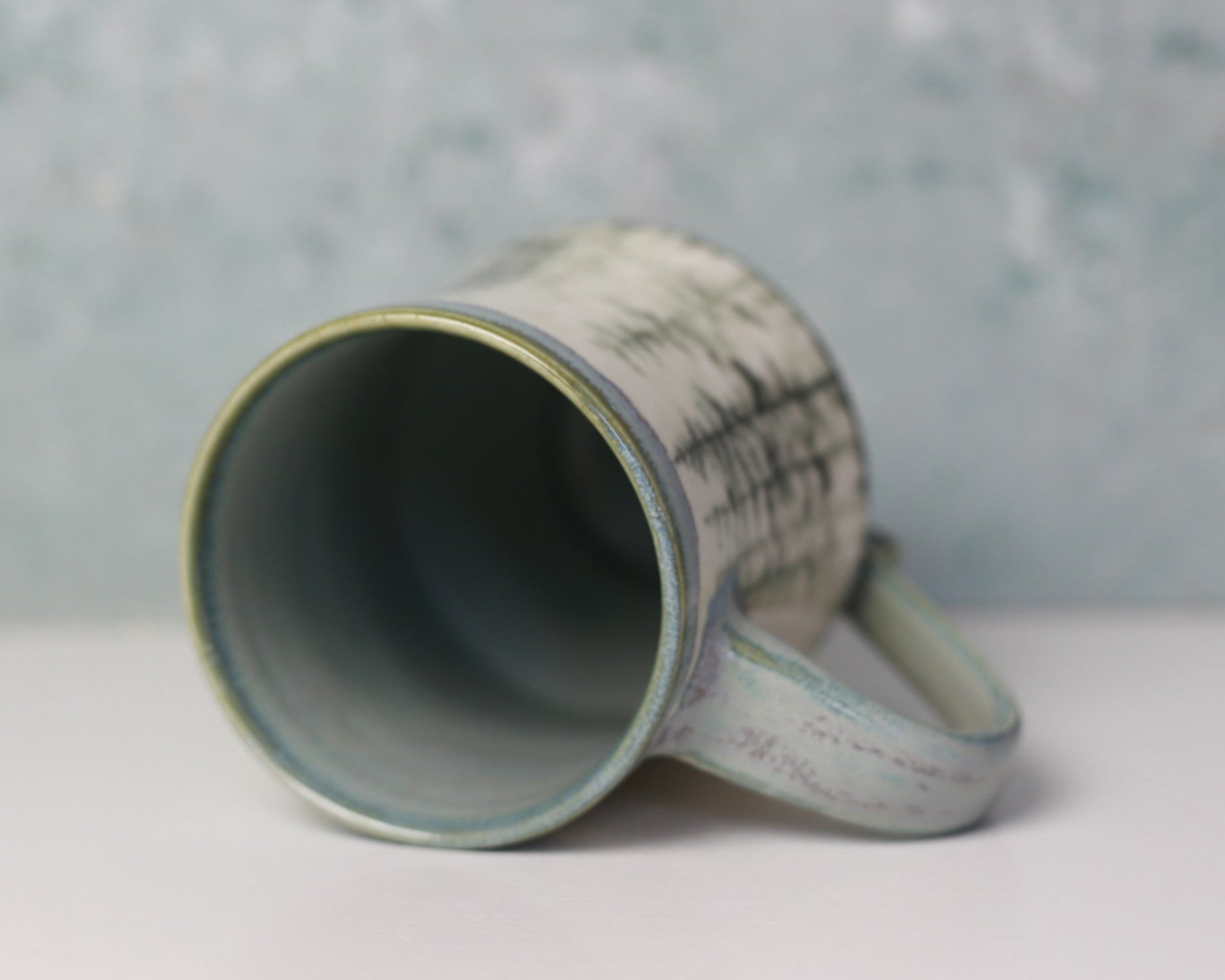 Ceramic mug with textured design on a gray background