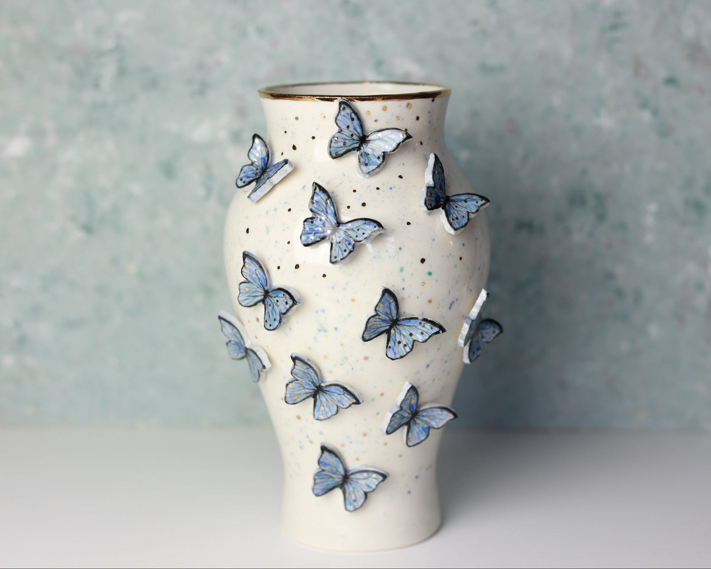 Ceramic vase with butterfly designs on a textured surface