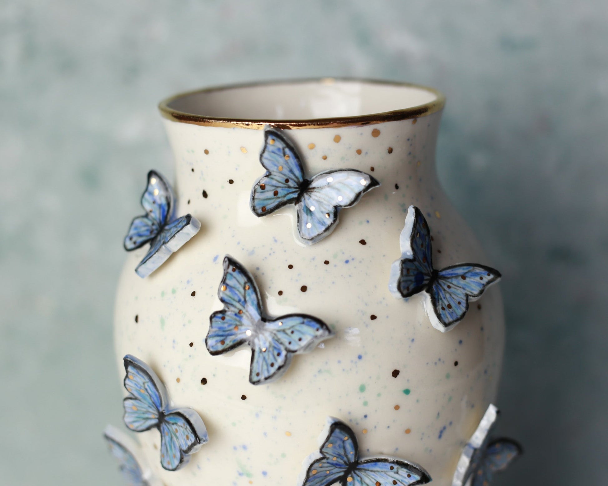 Ceramic vase with blue butterfly decorations on a textured gray background