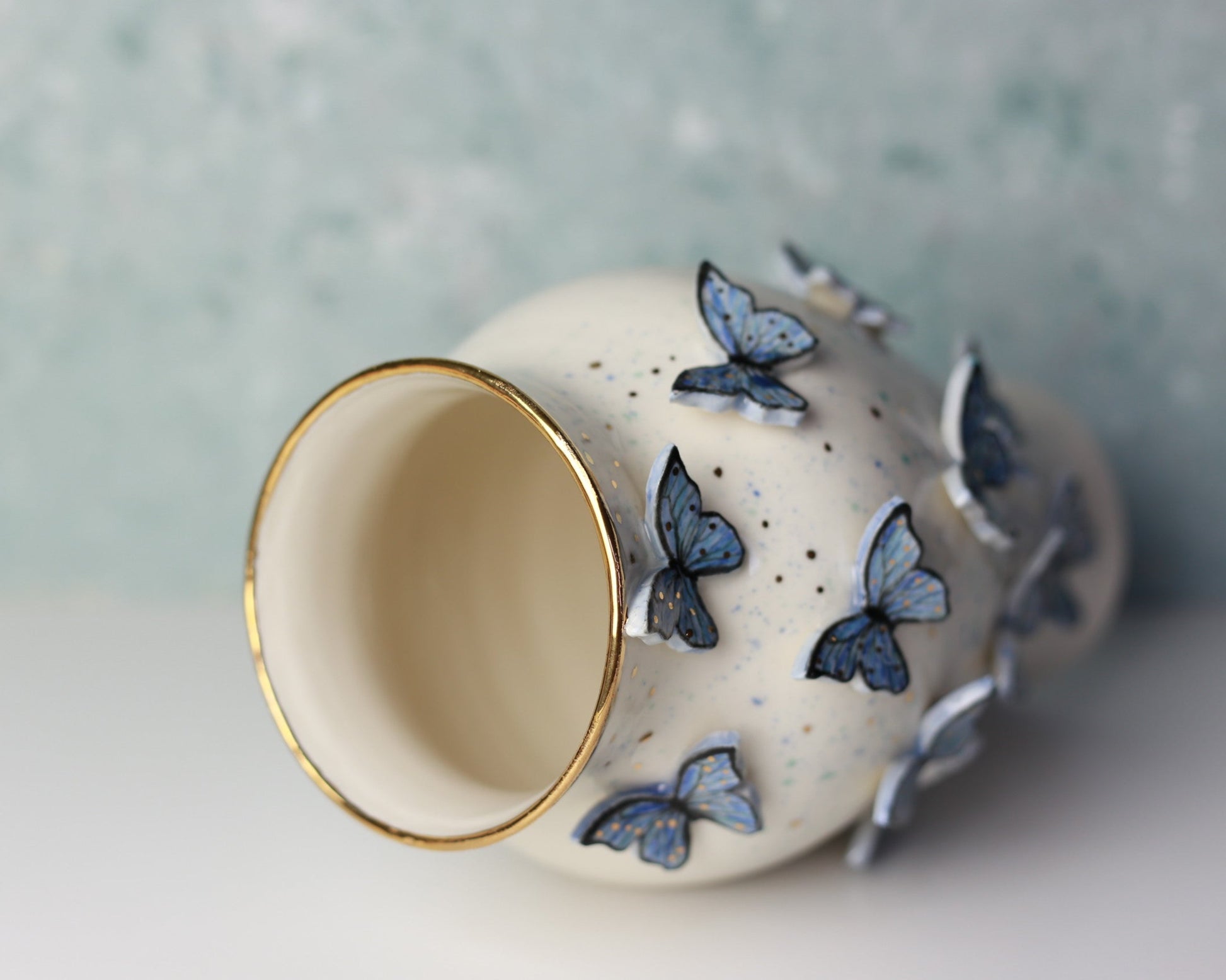 Ceramic vase with blue butterfly designs on a light background