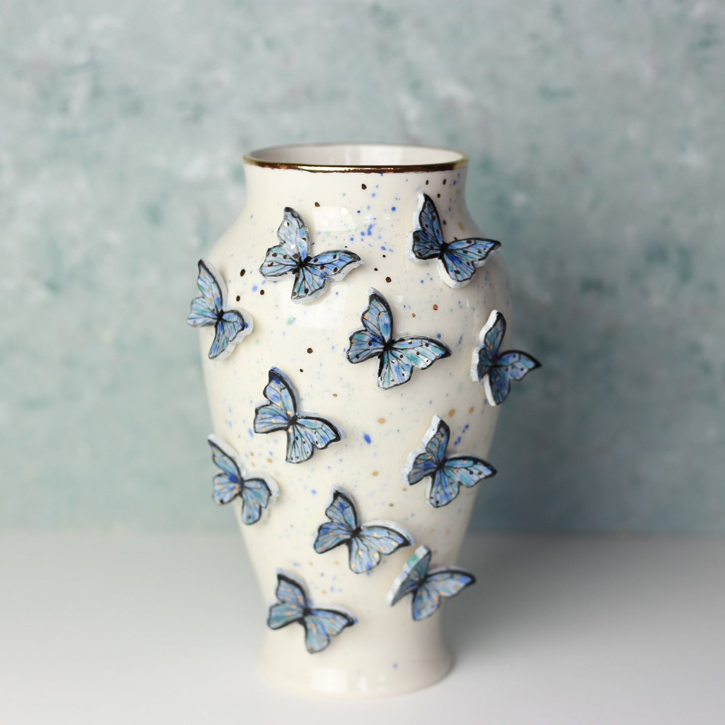 Ceramic vase with butterfly designs on a textured surface