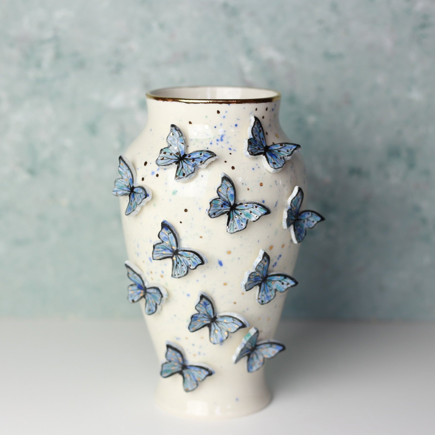Ceramic vase with butterfly designs on a textured surface