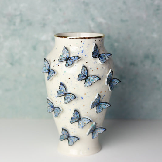 Ceramic vase with butterfly designs on a textured surface
