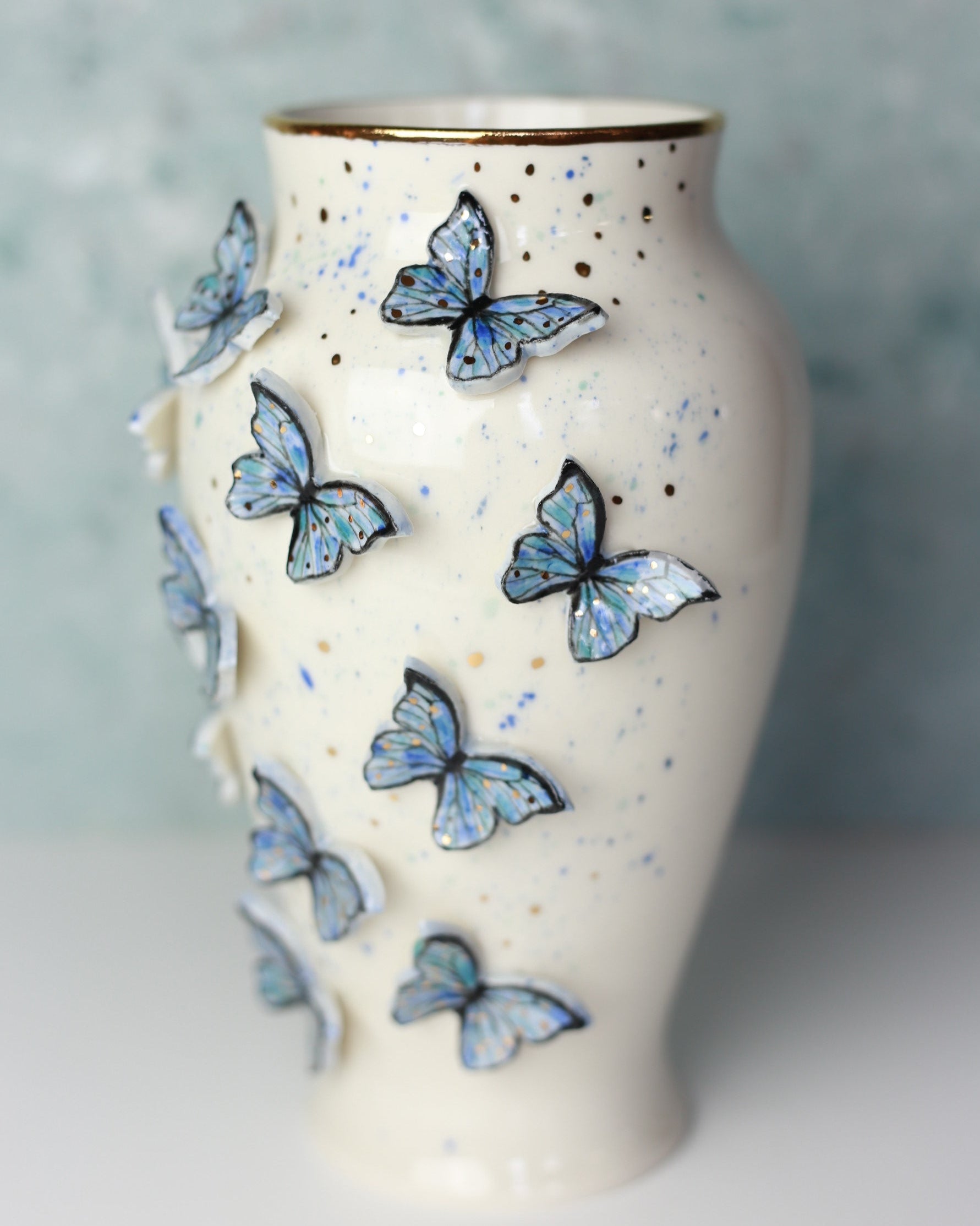 Ceramic vase with blue butterfly designs on a textured surface